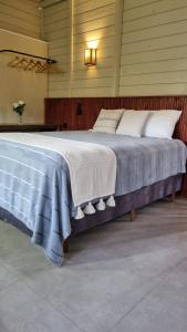 a large bed with a blue blanket on it at Cabana Bella Vista in Campo Alegre