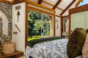 a bedroom with a bed and a large window at Amazing Riverside Retreat with Hot Tub & EcoPool in Mossel Bay