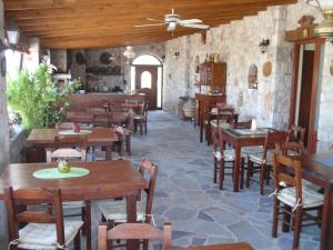 a restaurant with wooden tables and chairs in a room at Liros in Kamiros
