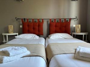 two beds sitting next to each other in a room at Hôtel Le Boïate in Arès