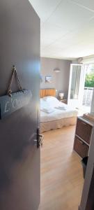 a refrigerator in a room with a bed in the background at Hôtel Le Boïate in Arès