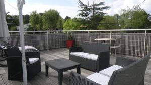 a patio with chairs and tables and a fence at Hôtel Le Boïate in Arès