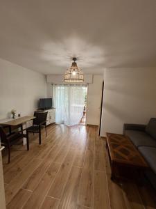 Appartement cosy piscine plage 2 pièces في فريجوس: غرفة معيشة مع أريكة وطاولة طعام