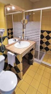 a bathroom with a sink and a toilet at Hôtel Le Boïate in Arès