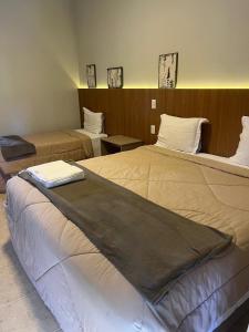two beds in a hotel room with at Pousada Apear in Andradas +18 photos
