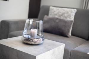 Landhaus Tannic في فينينغستيدت: شمعة في جرة زجاجية فوق طاولة