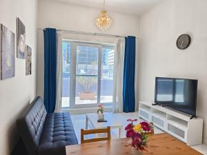 a living room with a couch and a tv at MK Residence JVC in Dubai