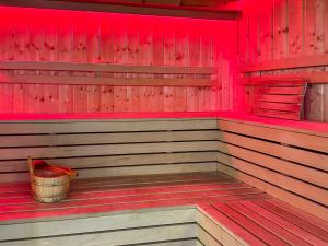 una sauna con cubo en una sala roja en Ours Living Kitzbüheler Alpen - inkl Sauna, en Hollersbach im Pinzgau