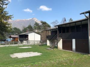 a building with a staircase in a yard with a mountain at Bungalow al Lago in Ledro