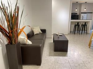 a living room with a black couch and a table at Torre Kalinka dos dormitorios pleno centro 6 personas in Villa Carlos Paz