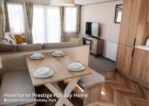 ein Wohnzimmer mit Tisch und Couch in der Unterkunft Golden Anchor Holiday Park in Chapel Saint Leonards