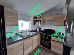 a kitchen with a stove and a sink with green lights at Seans 291 sandy cove 041 in Barmouth