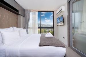 Ένα ή περισσότερα κρεβάτια σε δωμάτιο στο Tropics Kamala Hill View Suite CTG P610 near Beach and Fantasea +16 φωτογραφίες