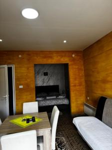 a room with a table and chairs and a bed at Apartments Vila Brzi & Beka in Šabac