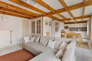 Una sala de estar con un sofá y una cocina. en Park Haerendycke Vis81, en Wenduine