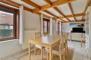 Un comedor con mesa y sillas de madera. en Park Haerendycke Vis81, en Wenduine 13 fotos más