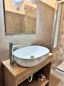 un bagno con un lavandino bianco e uno specchio di Welcome to I Colori di Napoli a Napoli