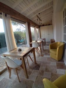une salle à manger avec tables, chaises et fenêtres dans l'établissement MaCoCo Maison Coeur Corbieres, à Fontjoncouse