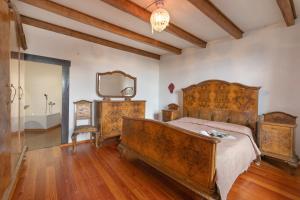 Un dormitorio con una cama de madera y un espejo. en Teseo House - Lake View - Happy Rentals, en Gardone Riviera