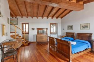 Un dormitorio con una cama y un techo de madera. en Teseo House - Lake View - Happy Rentals, en Gardone Riviera
