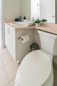 ein Badezimmer mit weißer Toilette und Waschbecken in der Unterkunft Luxury CN Tower Suites - Save on Monthly Stays in Toronto + 3 Fotos