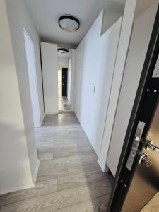 a hallway with white walls and a wooden floor at Milan Luxury Apartaments IX#Maurer Residence -Targu Mures in Târgu-Mureş