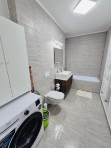 a bathroom with a washing machine and a sink at Milan Luxury Apartaments IX#Maurer Residence -Targu Mures in Târgu-Mureş