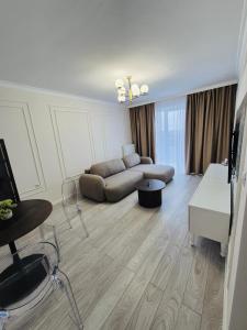 a living room with a couch and a table at Milan Luxury Apartaments IX#Maurer Residence -Targu Mures in Târgu-Mureş