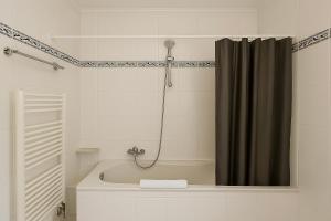 een badkamer met een bad en een douchegordijn bij Ferienwohnung Meeresrauschen in Schausende +7 foto's