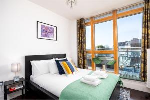 a bedroom with a bed and a large window at 2BR Dublin Apt Balcony, Plants & Electric Piano in Dublin