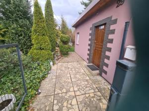 una passerella che conduce a una casa rosa con una porta di Lawendowy zakątek a Polanica-Zdrój