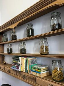 a wooden shelf with jars of food and books at Apartament Jezioro Łabędzie in Białla
