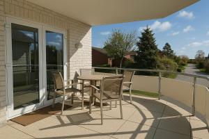 een tafel en stoelen op het balkon van een huis bij Ferienwohnung Meeresrauschen in Schausende
