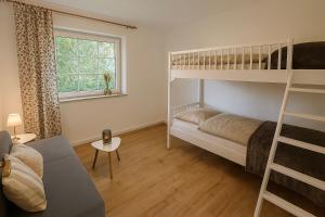 een woonkamer met stapelbedden en een bank bij Ferienwohnung Meeresrauschen in Schausende