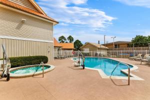a swimming pool in front of a building at SureStay Studio by Best Western Pensacola in Pensacola