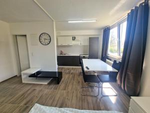 a room with a table and a clock on the wall at L11 Work & Stay Studio in Leverkusen