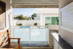 a view from the balcony of a house with a swimming pool at Apto espaçoso com piscina em Jurerê | CHR025 in Florianópolis