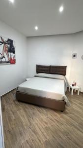 una camera da letto con un letto grande e un pavimento in legno di Miranda's house a Napoli