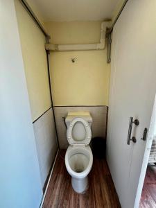 a small bathroom with a toilet in a stall at Chubbi 5 Room24 in Ban Bang Bamru