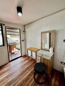 a bathroom with a sink and a mirror and a stool at Chubbi 5 Room24 in Ban Bang Bamru