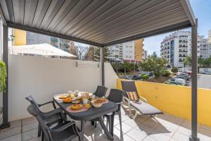 a patio with a table and chairs on a balcony at Apartamento Joana Praia da Rocha in Portimão
