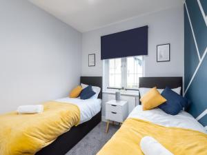 KentにあるCharming 3 Bed House For 5- City Central - Free Parkingのベッドルーム1室(黄色と青の枕が備わるベッド2台付)
