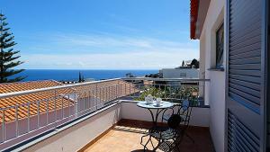 un balcone con tavolo e sedie e l'oceano di Madeira Serenity Cottage a Funchal