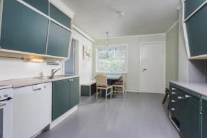a kitchen with green cabinets and a table in it at Heggmoen Lodge in Bodø