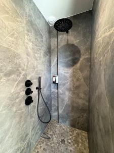 a shower with a shower head in a bathroom at Superbe Villa contemporaine avec piscine, Sainte Marine in Combrit