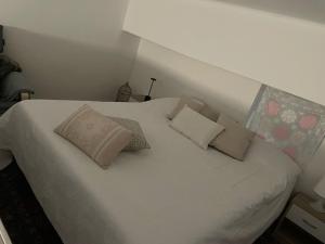 a white bed with pillows on it in a room at Al centro di Molfetta in Molfetta