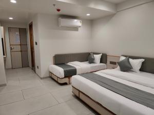 a hotel room with two beds in a room at Hotel Kozar in Ahmedabad
