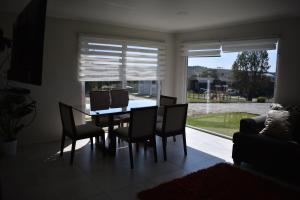 a dining room with a table and chairs and a window at Cabañas alto Volcanes, Puerto Montt in Puerto Montt