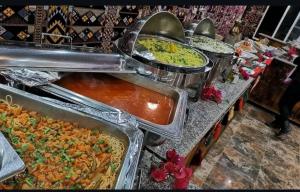 a buffet line with many different types of food at Al-Faris Camp in Disah