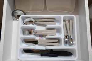 a white tray with utensils in a drawer at Moda Studio Apartment in Ohrid +26 photos
